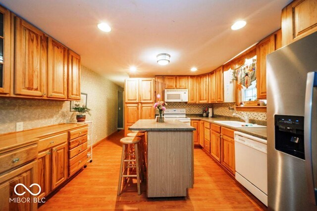 17310 N Willman Rd, Eaton, IN 47338 - kitchen with white appliances, a sink, light wood finished floors, a kitchen island, and backsplash