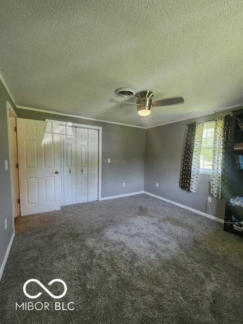 17310 N Willman Rd, Eaton, IN 47338 - unfurnished bedroom with a textured ceiling, crown molding, carpet flooring, baseboards, and a closet