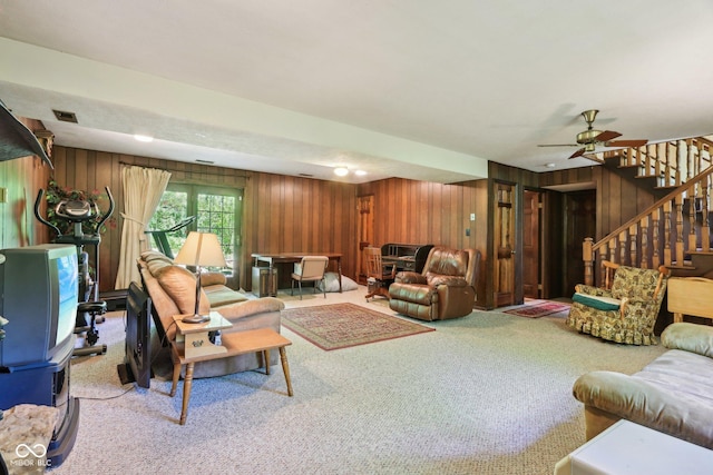 9240 E Woodview Dr, Bloomington, IN 47401 - living room featuring carpet, wood walls, stairs, and a ceiling fan