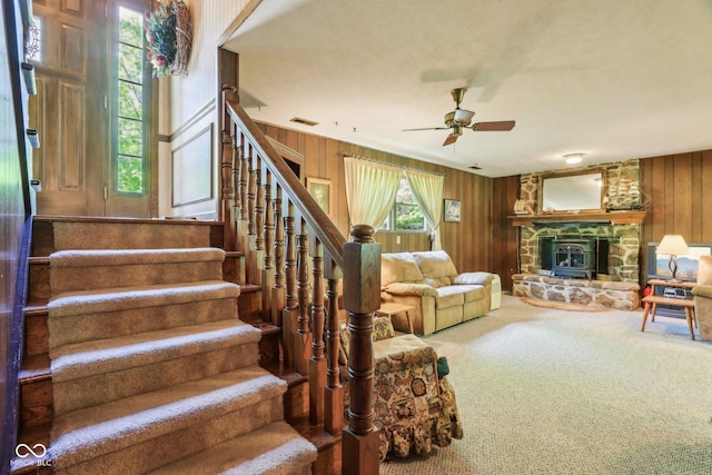 9240 E Woodview Dr, Bloomington, IN 47401 - stairway with a ceiling fan, carpet flooring, wooden walls, and a fireplace