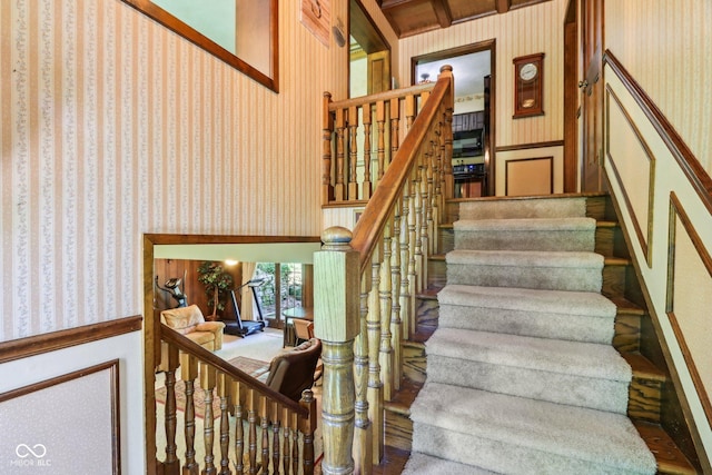 9240 E Woodview Dr, Bloomington, IN 47401 - stairway with wallpapered walls, a wainscoted wall, and a decorative wall
