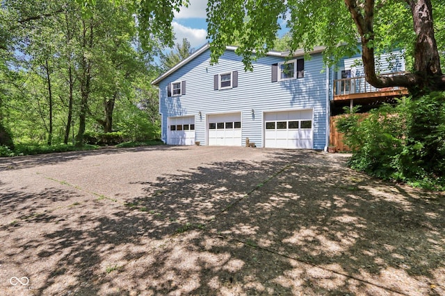 9240 E Woodview Dr, Bloomington, IN 47401 - view of property exterior with a garage, concrete driveway, and a deck