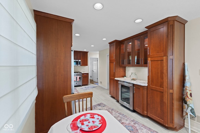 909 E Markwood Ave, Indianapolis, IN 46227 - kitchen featuring beverage cooler, appliances with stainless steel finishes, recessed lighting, light wood finished floors, and glass insert cabinets