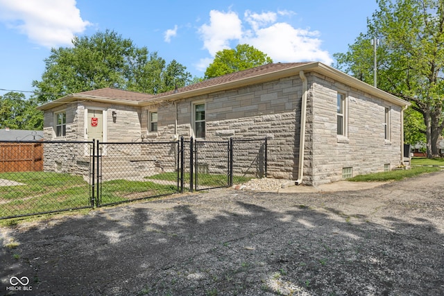 909 E Markwood Ave, Indianapolis, IN 46227 - view of side of property with a gate, stone siding, and a shingled roof