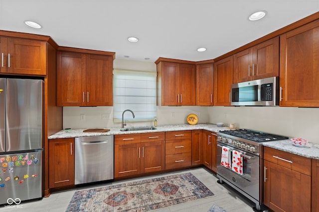 909 E Markwood Ave, Indianapolis, IN 46227 - kitchen featuring stainless steel appliances, a sink, light stone countertops, brown cabinetry, and recessed lighting