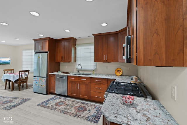 909 E Markwood Ave, Indianapolis, IN 46227 - kitchen featuring stainless steel appliances, a sink, light stone counters, light wood finished floors, and recessed lighting