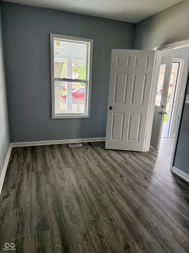 23 S Holmes Ave, Indianapolis, IN 46222 - unfurnished bedroom with dark wood-style floors and baseboards