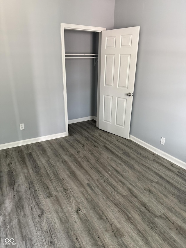 23 S Holmes Ave, Indianapolis, IN 46222 - unfurnished bedroom with baseboards, dark wood-style flooring, and a closet