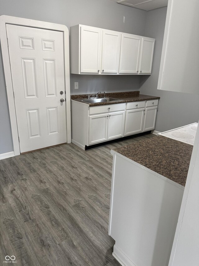 23 S Holmes Ave, Indianapolis, IN 46222 - kitchen with dark countertops, a sink, white cabinetry, and dark wood-style floors