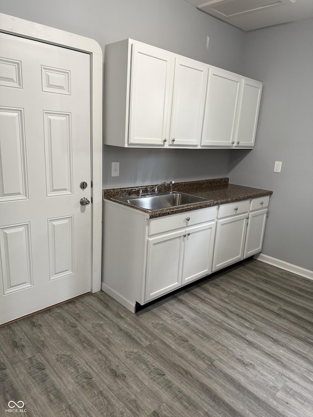 23 S Holmes Ave, Indianapolis, IN 46222 - kitchen with dark wood finished floors, dark countertops, baseboards, a sink, and white cabinetry