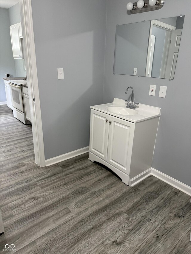 23 S Holmes Ave, Indianapolis, IN 46222 - bathroom featuring wood finished floors, baseboards, and vanity