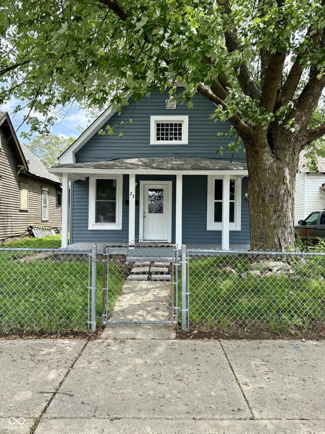 23 S Holmes Ave, Indianapolis, IN 46222 - shotgun-style home featuring a porch and a gate