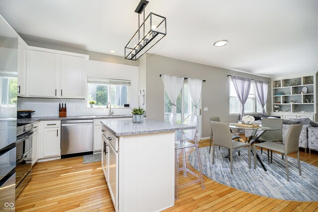 14135 Nicholas Dr, Carmel, IN 46074 - kitchen with stainless steel dishwasher, open floor plan, light wood-type flooring, a center island, and recessed lighting