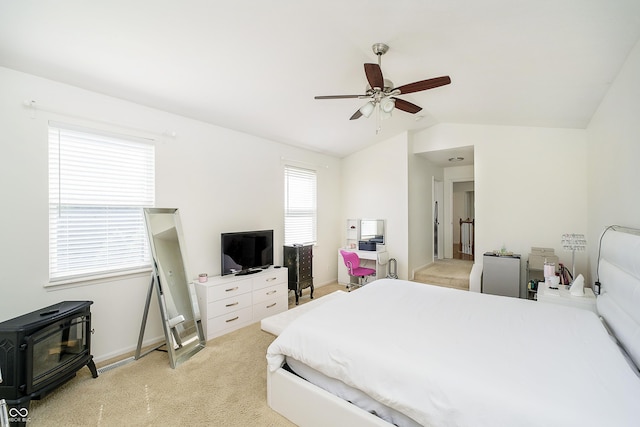14135 Nicholas Dr, Carmel, IN 46074 - bedroom featuring lofted ceiling, light colored carpet, a wood stove, ceiling fan, and baseboards