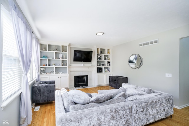 14135 Nicholas Dr, Carmel, IN 46074 - living room featuring a tiled fireplace, light wood finished floors, and baseboards