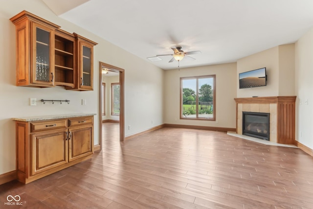 2825 S State Road 267, Plainfield, IN 46168 - unfurnished living room with ceiling fan, light wood-style floors, a tiled fireplace, and baseboards