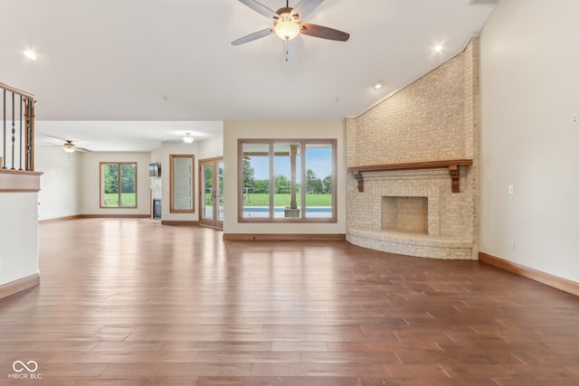 2825 S State Road 267, Plainfield, IN 46168 - unfurnished living room featuring a ceiling fan, wood finished floors, a fireplace, vaulted ceiling, and baseboards