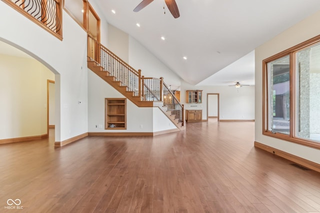 2825 S State Road 267, Plainfield, IN 46168 - unfurnished living room with a ceiling fan, stairs, arched walkways, hardwood / wood-style floors, and high vaulted ceiling