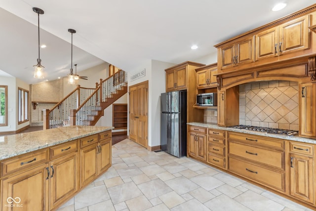 2825 S State Road 267, Plainfield, IN 46168 - kitchen featuring stainless steel appliances, tasteful backsplash, ceiling fan, brown cabinetry, and light stone countertops