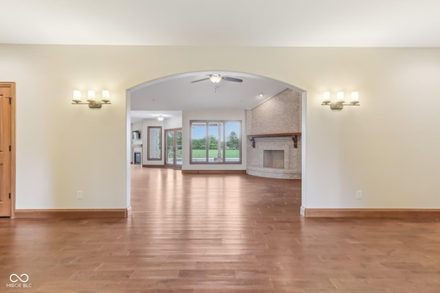 2825 S State Road 267, Plainfield, IN 46168 - unfurnished living room featuring wood finished floors, arched walkways, a ceiling fan, and baseboards