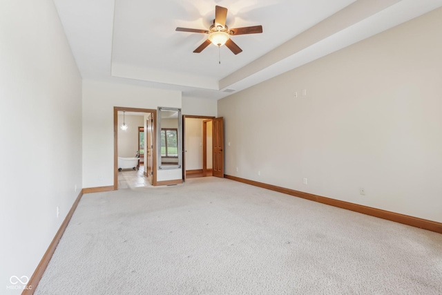2825 S State Road 267, Plainfield, IN 46168 - unfurnished bedroom featuring a raised ceiling, baseboards, light carpet, ensuite bathroom, and ceiling fan