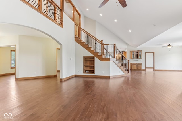 2825 S State Road 267, Plainfield, IN 46168 - unfurnished living room with a ceiling fan, high vaulted ceiling, stairs, arched walkways, and hardwood / wood-style floors