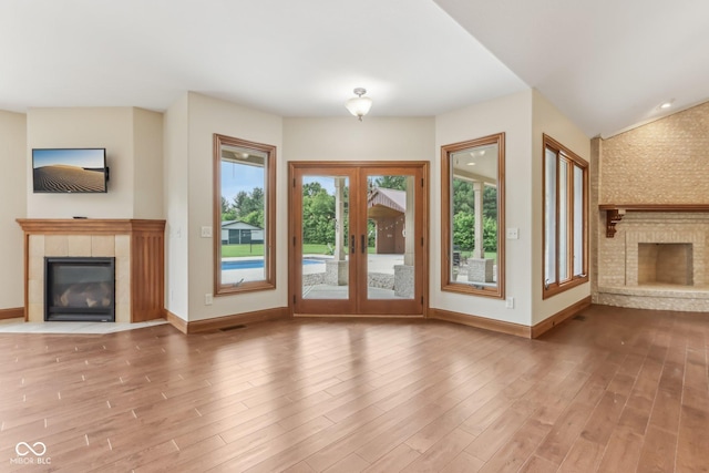 2825 S State Road 267, Plainfield, IN 46168 - unfurnished living room featuring a fireplace, french doors, baseboards, and wood finished floors
