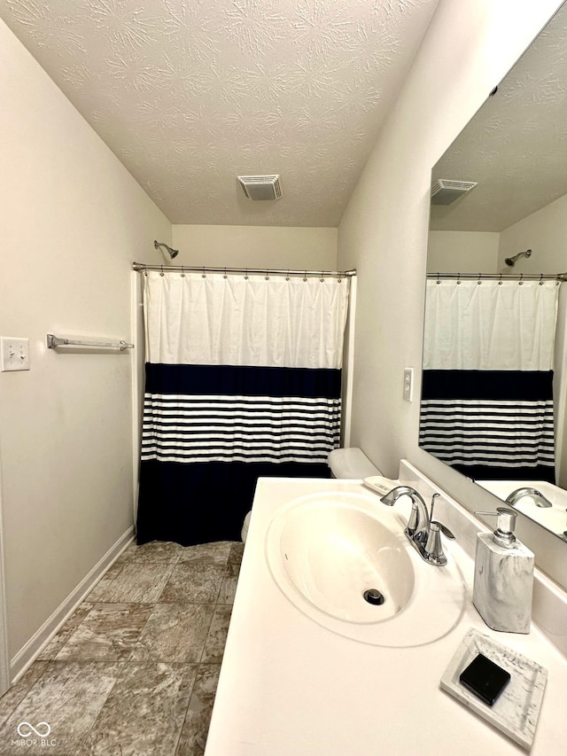 1880 Explorer Ct, Franklin, IN 46131 - full bathroom featuring baseboards, vanity, a textured ceiling, stone finish floors, and a shower with shower curtain
