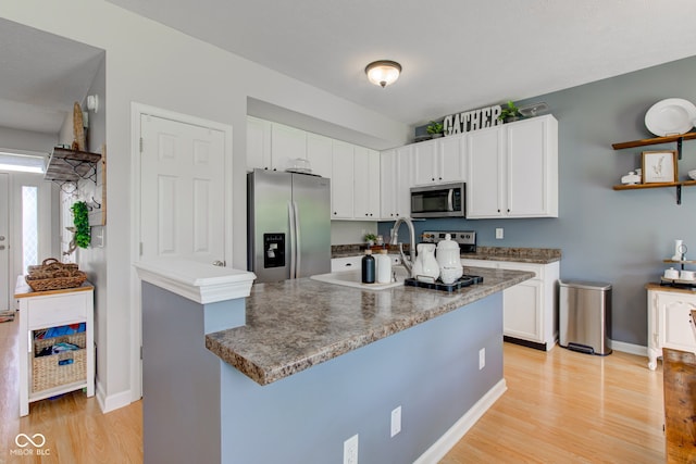 7452 Lace Bark Ct, Avon, IN 46123 - kitchen with appliances with stainless steel finishes, white cabinets, light wood-style floors, dark countertops, and an island with sink