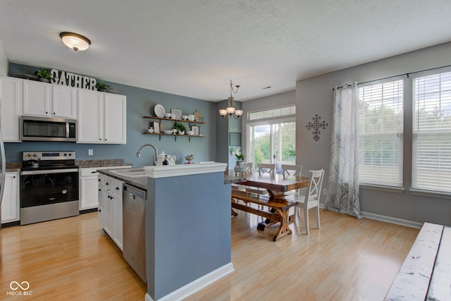 7452 Lace Bark Ct, Avon, IN 46123 - kitchen featuring stainless steel appliances, a sink, light wood-style floors, white cabinets, and a textured ceiling