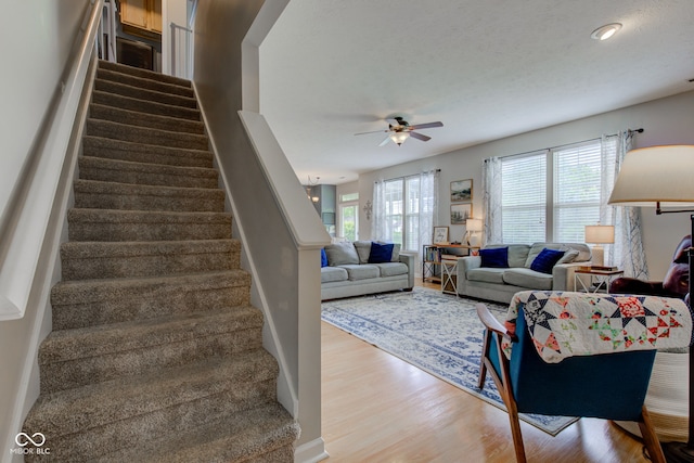 7452 Lace Bark Ct, Avon, IN 46123 - living area with wood finished floors, ceiling fan, and stairway