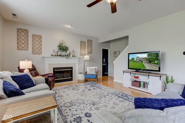 7452 Lace Bark Ct, Avon, IN 46123 - living room featuring a ceiling fan, a tiled fireplace, wood finished floors, and baseboards