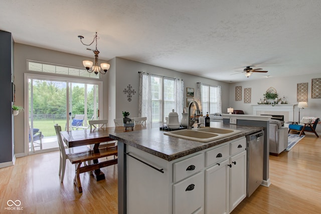 7452 Lace Bark Ct, Avon, IN 46123 - kitchen featuring dark countertops, a sink, stainless steel dishwasher, light wood-type flooring, and white cabinets