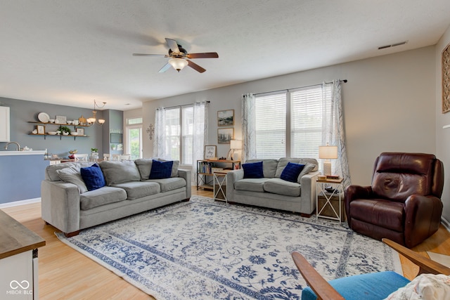 7452 Lace Bark Ct, Avon, IN 46123 - living room with light wood-type flooring, a ceiling fan, and a chandelier