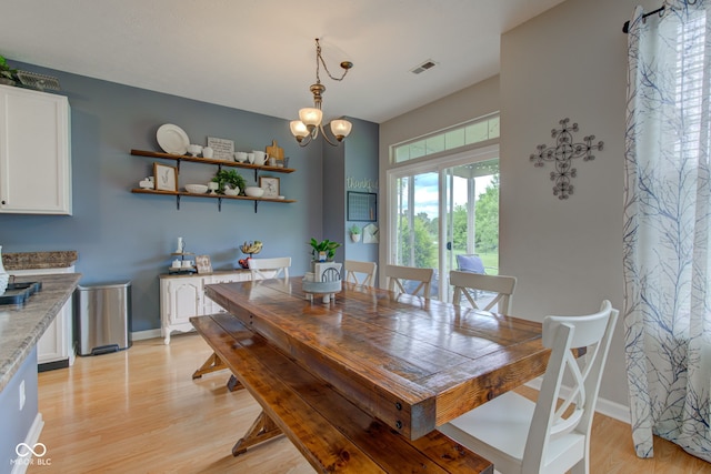 7452 Lace Bark Ct, Avon, IN 46123 - dining space featuring light wood-type flooring, baseboards, and a chandelier