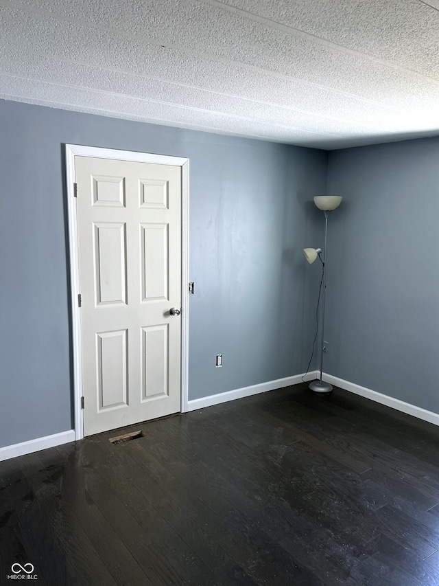 261 S Main St, Marshall, IN 47859 - empty room featuring dark wood-style floors, baseboards, and a textured ceiling