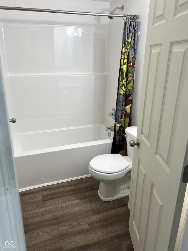 261 S Main St, Marshall, IN 47859 - bathroom featuring wood finished floors, toilet, and shower / bathtub combination with curtain