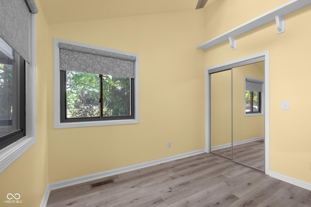 740 Carya Sq, Columbus, IN 47201 - unfurnished bedroom with multiple windows, wood finished floors, baseboards, lofted ceiling, and a closet