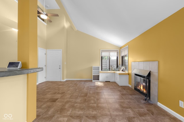 740 Carya Sq, Columbus, IN 47201 - unfurnished living room featuring high vaulted ceiling, a tiled fireplace, a ceiling fan, tile patterned floors, and baseboards