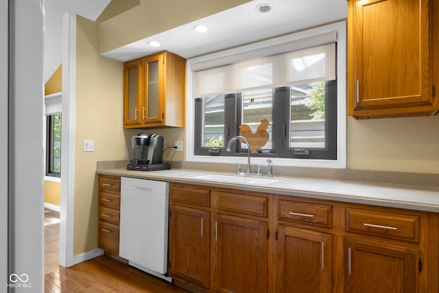 740 Carya Sq, Columbus, IN 47201 - kitchen featuring dishwasher, a sink, light countertops, brown cabinetry, and glass insert cabinets