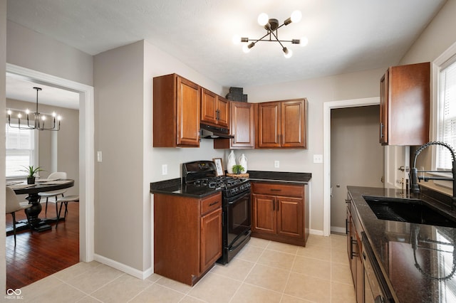 5232 E 10th St, Indianapolis, IN 46219 - kitchen featuring a chandelier, black gas stove, under cabinet range hood, a sink, and brown cabinets