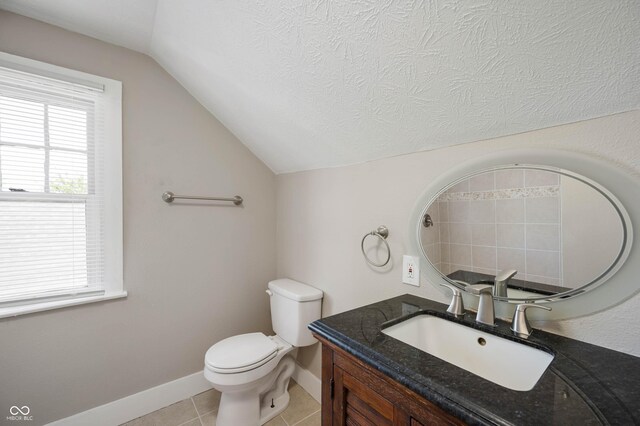 5232 E 10th St, Indianapolis, IN 46219 - bathroom with lofted ceiling, toilet, vanity, baseboards, and tile patterned flooring