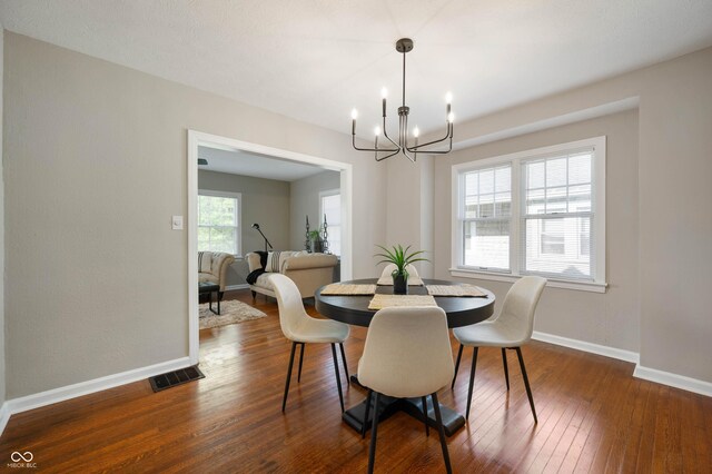 5232 E 10th St, Indianapolis, IN 46219 - dining room with a chandelier, baseboards, and dark wood-type flooring