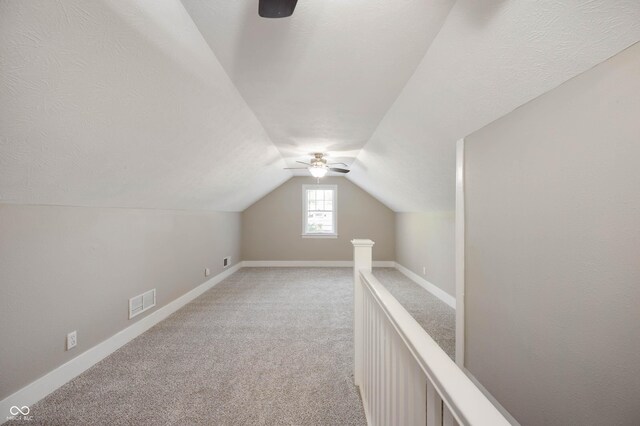 5232 E 10th St, Indianapolis, IN 46219 - bonus room featuring a ceiling fan, lofted ceiling, light colored carpet, and baseboards