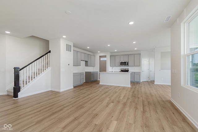 2705 Penn Ave, Plainfield, IN 46168 - unfurnished living room with light wood-type flooring, stairway, and recessed lighting