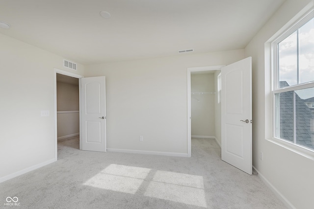 2705 Penn Ave, Plainfield, IN 46168 - unfurnished bedroom featuring light colored carpet, a spacious closet, and a closet
