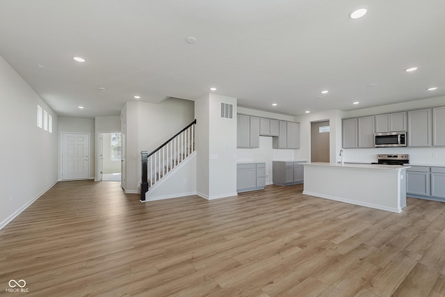 2705 Penn Ave, Plainfield, IN 46168 - unfurnished living room featuring recessed lighting, light wood-type flooring, and stairs