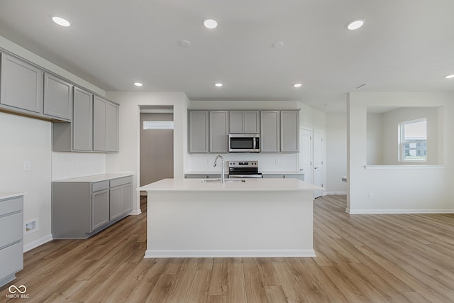 2705 Penn Ave, Plainfield, IN 46168 - kitchen featuring stainless steel appliances, gray cabinets, a kitchen island with sink, light wood finished floors, and recessed lighting