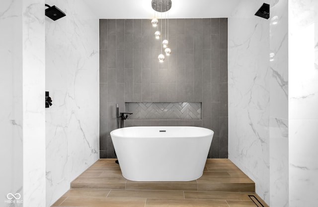 19 E Regent St, Indianapolis, IN 46225 - bathroom with tile walls, a soaking tub, a shower, and wood finish floors
