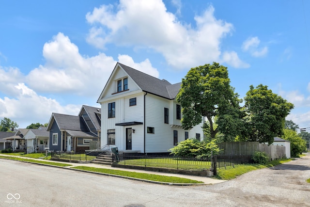 19 E Regent St, Indianapolis, IN 46225 - view of front of house featuring a fenced front yard, board and batten siding, a residential view, and a shingled roof